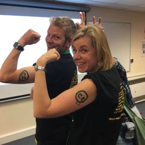 Jane and Chris showing Creative Commons symbols as fake tatoos on their arms